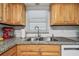 Kitchen features stainless steel sink, tile backsplash, and natural wood cabinets at 1270 Inverness, Dunedin, FL 34698
