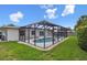 Backyard view of a sparkling pool within a screened lanai and lush green yard at 1270 Inverness, Dunedin, FL 34698