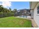 Backyard view of the screened-in pool with lush green landscaping and adjacent outdoor seating area at 1270 Inverness, Dunedin, FL 34698