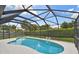 A sparkling blue pool surrounded by a screened enclosure and lush landscaping at 1270 Inverness, Dunedin, FL 34698