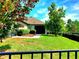 Green backyard featuring a covered patio, lush lawn, and well-maintained landscaping and an iron fence at 12862 Rangeland Blvd, Odessa, FL 33556