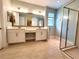 Bathroom with double sink vanity, large mirror, and glass-enclosed shower and tile floors at 12862 Rangeland Blvd, Odessa, FL 33556