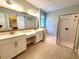 Bathroom featuring dual vanities, a large mirror, and a glass-enclosed shower at 12862 Rangeland Blvd, Odessa, FL 33556