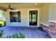 Covered front porch with brick accents, dark shutters, and elegant double door at 12862 Rangeland Blvd, Odessa, FL 33556