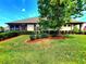 Charming home featuring a well-kept lawn, mature trees, and manicured shrubs, enhancing its curb appeal at 12862 Rangeland Blvd, Odessa, FL 33556