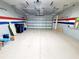 Spacious garage with overhead racks and an epoxy-coated floor offering ample room for parking and storage at 12862 Rangeland Blvd, Odessa, FL 33556