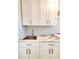 The laundry room features stone countertops, a sink, and white cabinets for storage at 12862 Rangeland Blvd, Odessa, FL 33556