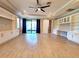 Spacious living room with tile flooring, built-in shelving, and sliding glass doors to patio at 12862 Rangeland Blvd, Odessa, FL 33556