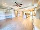 Bright living room with tile floors, ceiling fan, built-in shelving, and open access to the kitchen at 12862 Rangeland Blvd, Odessa, FL 33556