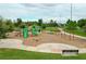 Community playground area featuring slides, swings, and a seesaw, with a walking path and bench at 12862 Rangeland Blvd, Odessa, FL 33556