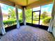 Relaxing screened porch with brick pavers and airy curtains, perfect for enjoying the outdoors at 12862 Rangeland Blvd, Odessa, FL 33556