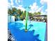 Community splash pad featuring palm tree sprinklers for Gathering fun on a blue, non-slip surface at 12862 Rangeland Blvd, Odessa, FL 33556