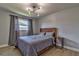Neutral bedroom featuring wood flooring, a wood bed frame, and a modern light fixture at 13029 111Th Ln, Largo, FL 33778