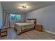 Bedroom with wood flooring, a wood bed frame, a window, and matching nightstands at 13029 111Th Ln, Largo, FL 33778
