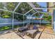 Backyard with a screened-in pool area with lounge chairs and pavers at 13029 111Th Ln, Largo, FL 33778