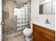 Bathroom featuring glass block wall shower and wood vanity with sink at 13148 3Rd E St, Madeira Beach, FL 33708