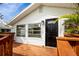 A charming entrance with a black front door and a newly stained wood deck, complemented by lush landscaping at 13148 3Rd E St, Madeira Beach, FL 33708