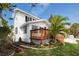 Charming two-story home showcasing the newly stained wood deck, lush landscaping, and a well-maintained yard at 13148 3Rd E St, Madeira Beach, FL 33708