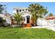 Charming two-story home featuring a front yard and beautiful tropical landscaping around the entrance at 13148 3Rd E St, Madeira Beach, FL 33708
