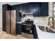 Kitchen with stainless steel appliances, white countertops and blue cabinets at 13148 3Rd E St, Madeira Beach, FL 33708