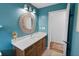 Bathroom with a decorative mirror over a wooden vanity and blue walls at 13501 Avista Dr, Tampa, FL 33624