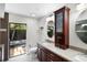 Bright bathroom with granite countertops and dark wood cabinets, leading to the outdoors at 13501 Avista Dr, Tampa, FL 33624