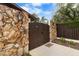 Front entrance with a wooden gate, stone accents, and stylish outdoor lighting for added security at 13501 Avista Dr, Tampa, FL 33624