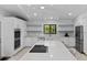 Modern kitchen with large island, stainless steel appliances and sleek white cabinets at 13501 Avista Dr, Tampa, FL 33624