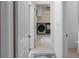 Hallway view of laundry room featuring modern appliances and storage at 13501 Avista Dr, Tampa, FL 33624