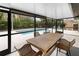 Screened patio features an outdoor dining area with views of the pool and backyard at 13501 Avista Dr, Tampa, FL 33624