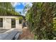 Exterior view of a landscaped side yard featuring lush greenery and a pathway at 13501 Avista Dr, Tampa, FL 33624