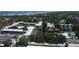 Aerial view of a condo complex featuring a central pond, fountain, and community pool near the ocean at 14130 Rosemary Ln # 3202, Largo, FL 33774