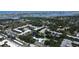 An aerial view of a condo community featuring a pond, swimming pool, and mature trees at 14130 Rosemary Ln # 3202, Largo, FL 33774