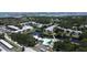 Aerial view of a condo complex featuring a central pond, fountain, and community pool near the ocean at 14130 Rosemary Ln # 3202, Largo, FL 33774