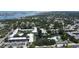 Aerial view of the condo complex shows a pool, central ponds, assigned parking, and lush landscaping at 14130 Rosemary Ln # 3202, Largo, FL 33774