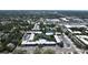 Aerial view of condominium community featuring water features, landscaping, community pool, and parking at 14130 Rosemary Ln # 3202, Largo, FL 33774