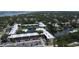 Aerial view of a condo complex featuring a central pond, fountain, and community pool near the ocean at 14130 Rosemary Ln # 3202, Largo, FL 33774