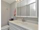 Neutral bathroom with a mirrored medicine cabinet, white vanity, and ample lighting at 14130 Rosemary Ln # 3202, Largo, FL 33774