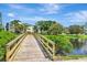 A wooden bridge extends over pond showcasing community landscaping and residential buildings at 14130 Rosemary Ln # 3202, Largo, FL 33774