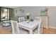 Bright dining area adjacent to the living room with a white table and gray cushioned chairs at 14130 Rosemary Ln # 3202, Largo, FL 33774