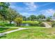 Scenic community pond featuring a charming wooden bridge, lush landscaping, and relaxing green space at 14130 Rosemary Ln # 3202, Largo, FL 33774