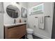 Modern bathroom with wood vanity, black fixtures, and stylish round mirror at 1650 22Nd N Ave, St Petersburg, FL 33713