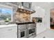 Gourmet kitchen boasts stainless steel range and hood, white cabinetry, and stone backsplash at 1650 22Nd N Ave, St Petersburg, FL 33713