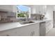 Gourmet kitchen features stainless steel sink, stone countertops and backsplash, and modern fixtures at 1650 22Nd N Ave, St Petersburg, FL 33713