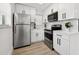 Modern kitchen boasting stainless steel appliances, white cabinetry, and wood grain flooring at 1650 22Nd N Ave, St Petersburg, FL 33713