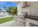 Well-equipped outdoor kitchen with a stainless steel grill and range hood, positioned near the pool at 1650 22Nd N Ave, St Petersburg, FL 33713