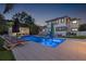 Stunning backyard pool featuring lounge chairs, lighting, and a beautifully landscaped yard, perfect for relaxing evenings at 1650 22Nd N Ave, St Petersburg, FL 33713
