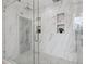 Stylish walk-in shower with marble tile, a glass door, and built-in shelving for added convenience at 1650 22Nd N Ave, St Petersburg, FL 33713