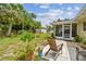 Spacious backyard featuring a cozy screened-in patio, mature trees, lush lawn, and an outdoor shed at 1707 Cardinal Dr, Clearwater, FL 33759