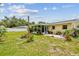 Well-maintained backyard showcasing a screened-in lanai, patio area, mature trees, and ample green space at 1707 Cardinal Dr, Clearwater, FL 33759